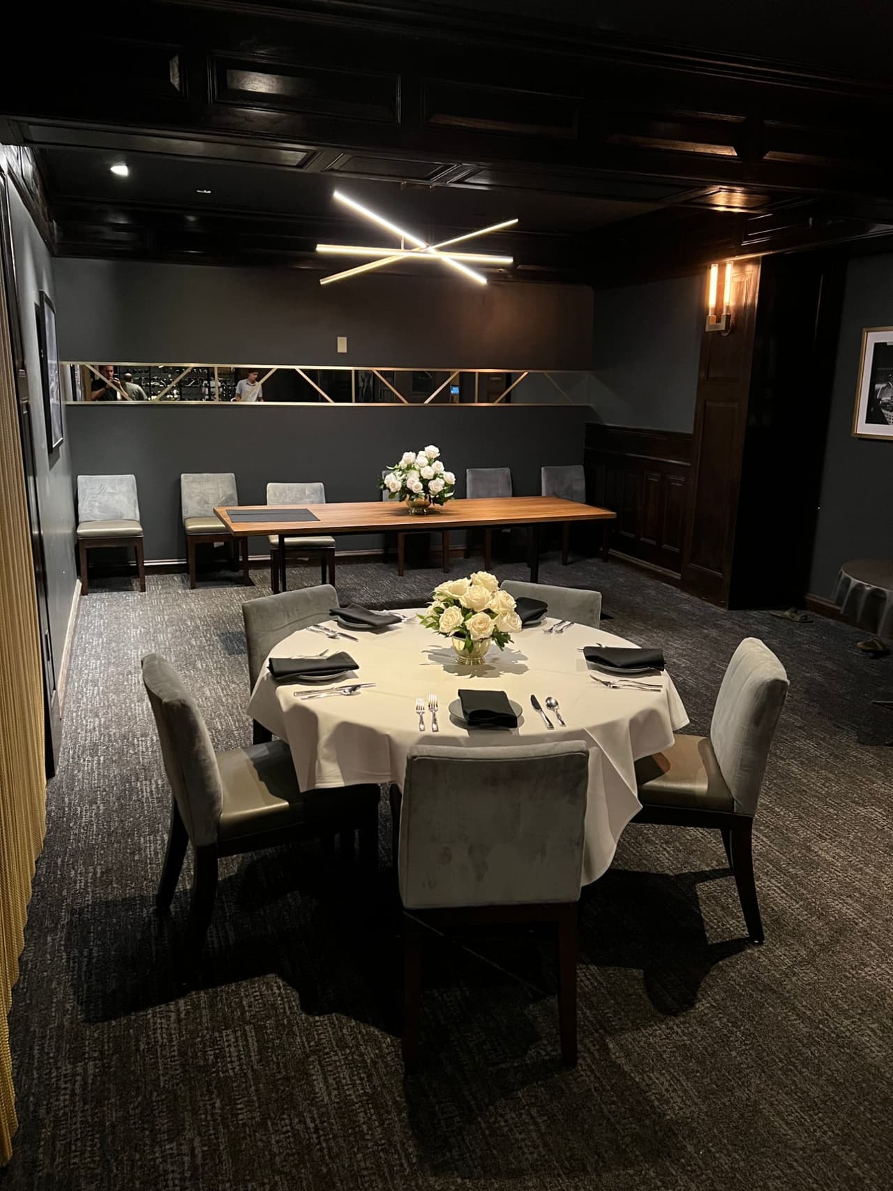 A round table and a long wooden table Upstairs under a star-shaped light